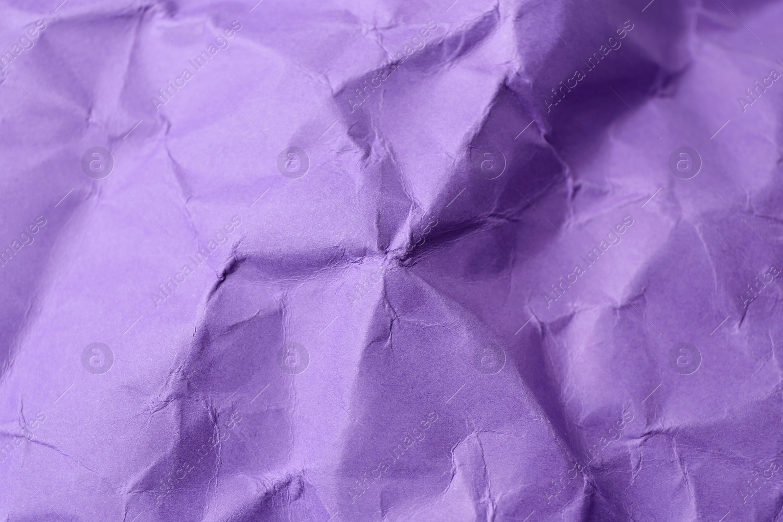 Photo of Sheet of crumpled violet paper as background, top view