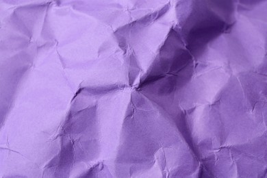 Sheet of crumpled violet paper as background, top view