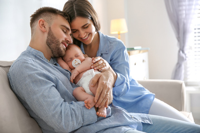 Happy couple with their newborn baby at home