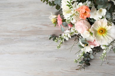 Photo of Bouquet of beautiful flowers on wooden table, space for text