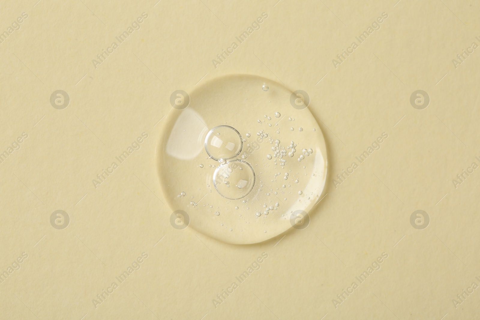 Photo of Sample of cosmetic serum on beige background, top view