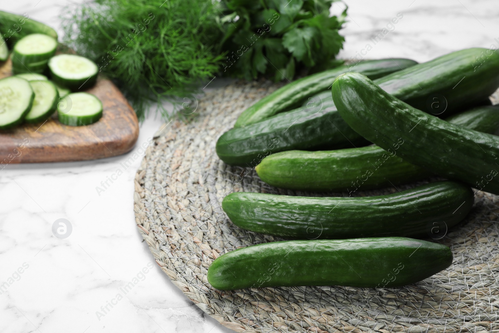 Photo of Fresh ripe cucumbers on white marble table, space for text