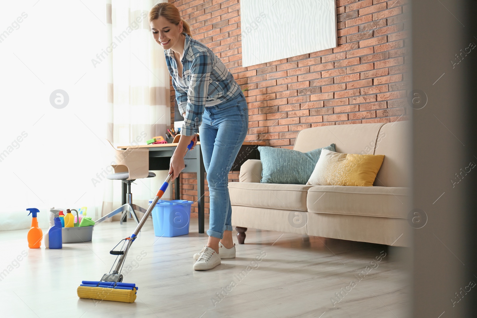 Photo of Woman cleaning floor with mop in living room