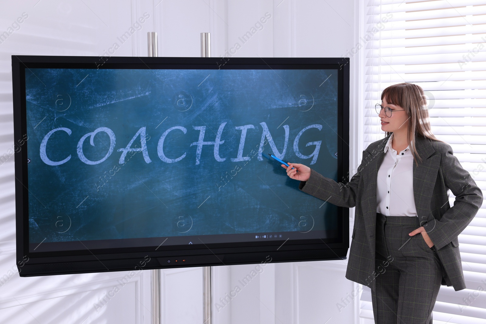 Photo of Business trainer using interactive board in meeting room