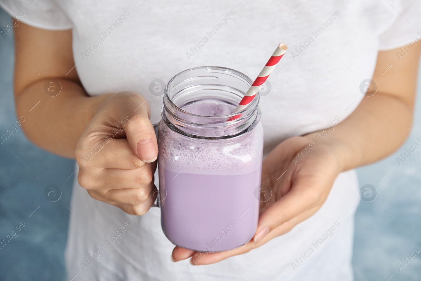 Photo of Woman with mason jar of delicious milk shake, closeup