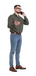 Man in shirt and jeans talking on phone on white background