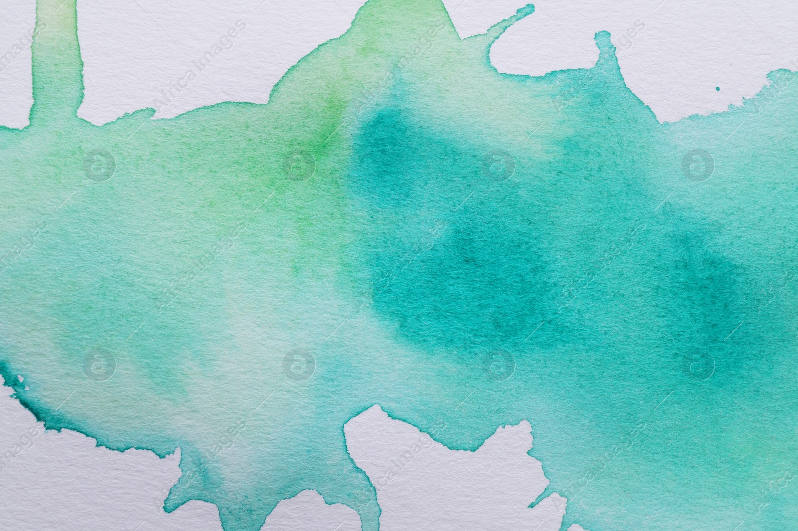 Photo of Abstract green watercolor paint on white canvas, top view