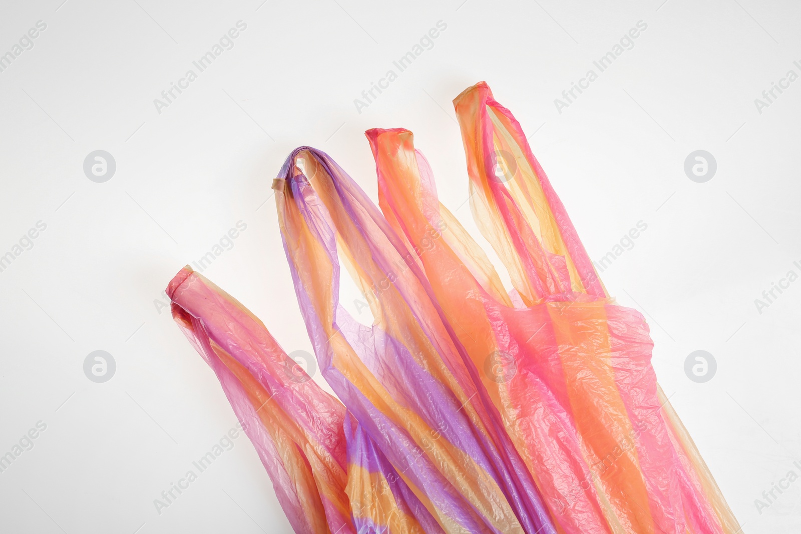 Photo of Color plastic bags isolated on white, top view