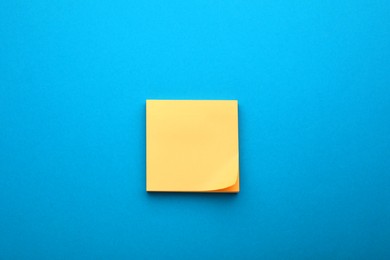 Paper note on blue background, top view