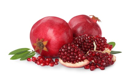 Tasty ripe pomegranates and leaves on white background