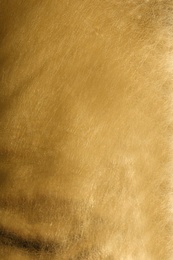 Photo of Shiny golden leather as background, top view