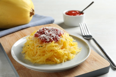 Photo of Cooked spaghetti squash served with sauce and cheese on plate