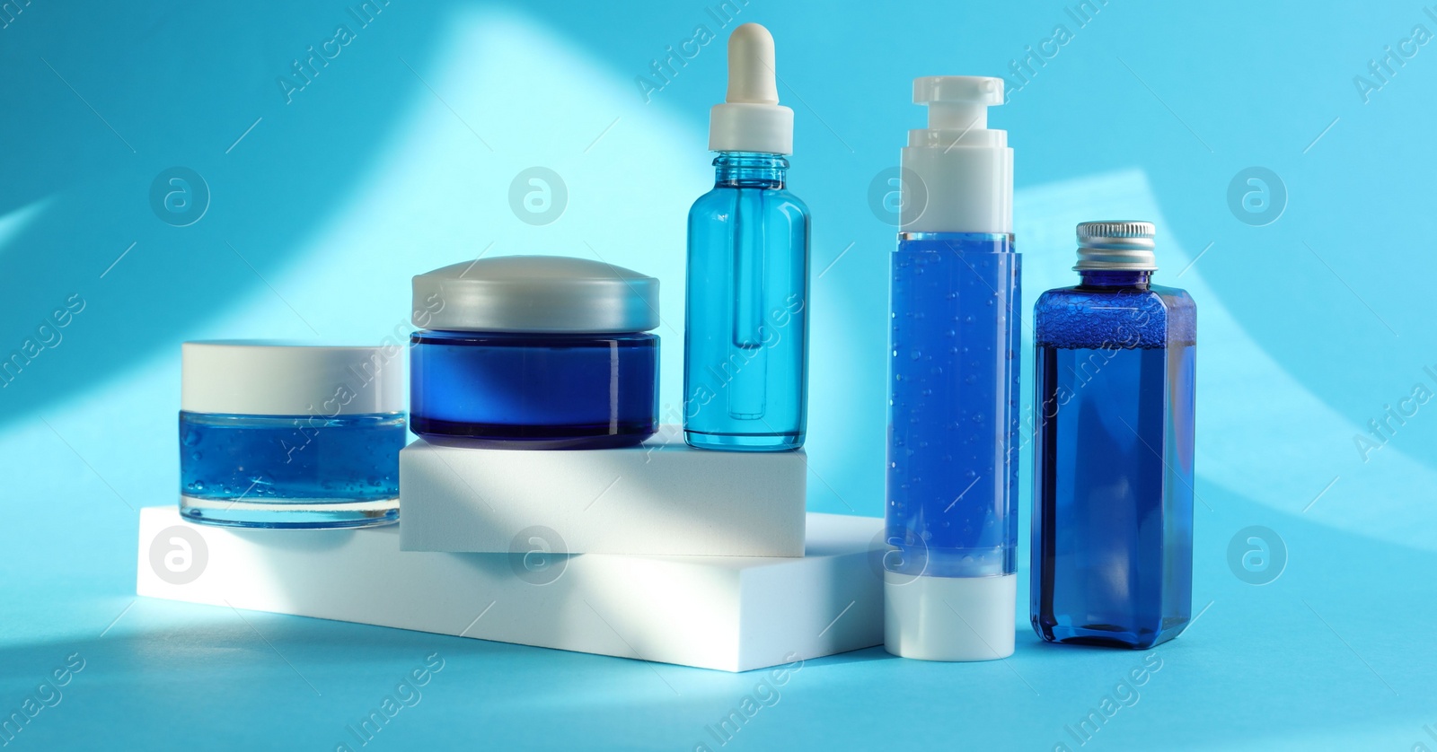 Photo of Set of luxury cosmetic products on light blue background