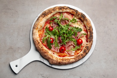 Photo of Tasty pizza with meat and arugula on grey table, top view