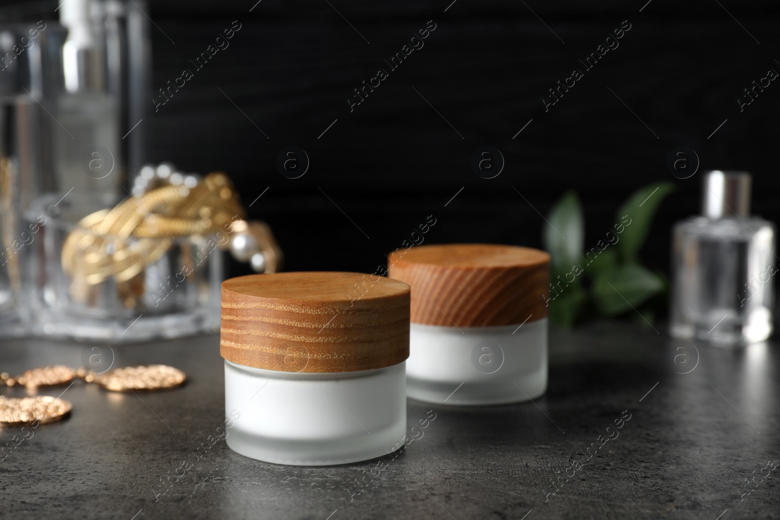 Photo of Jars with cream on black table. Cosmetic product