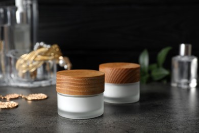 Jars with cream on black table. Cosmetic product