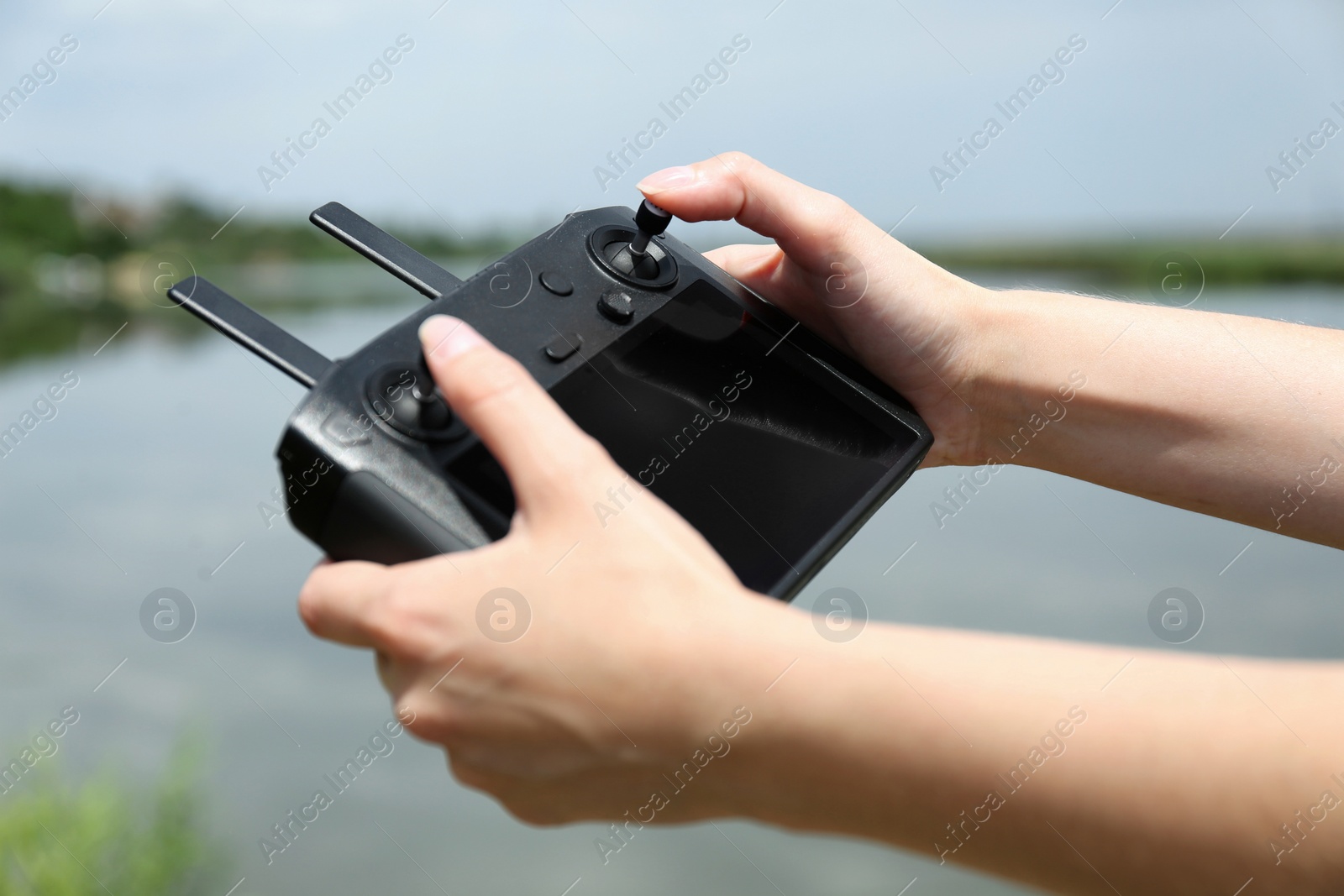 Photo of Woman with modern drone controller outdoors, closeup