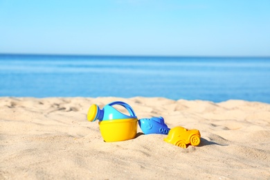 Photo of Set of plastic beach toys on sand near sea