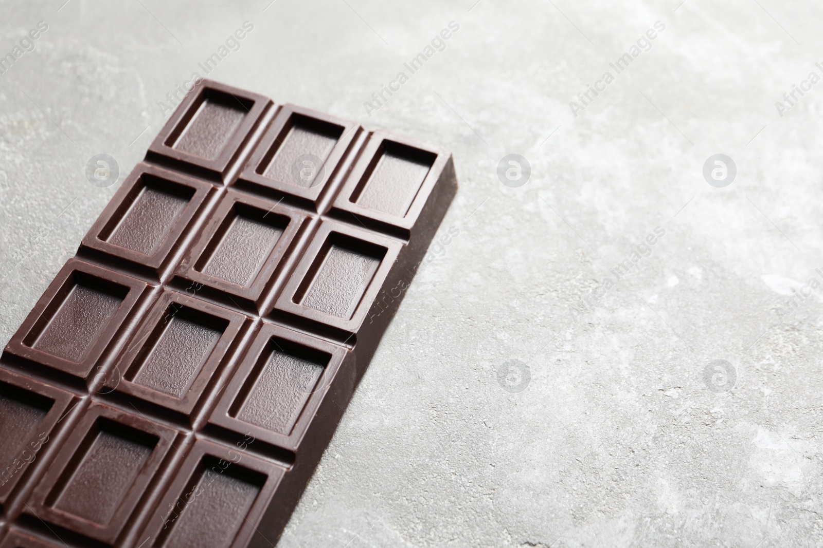 Photo of Chocolate bar on grey background. Space for text