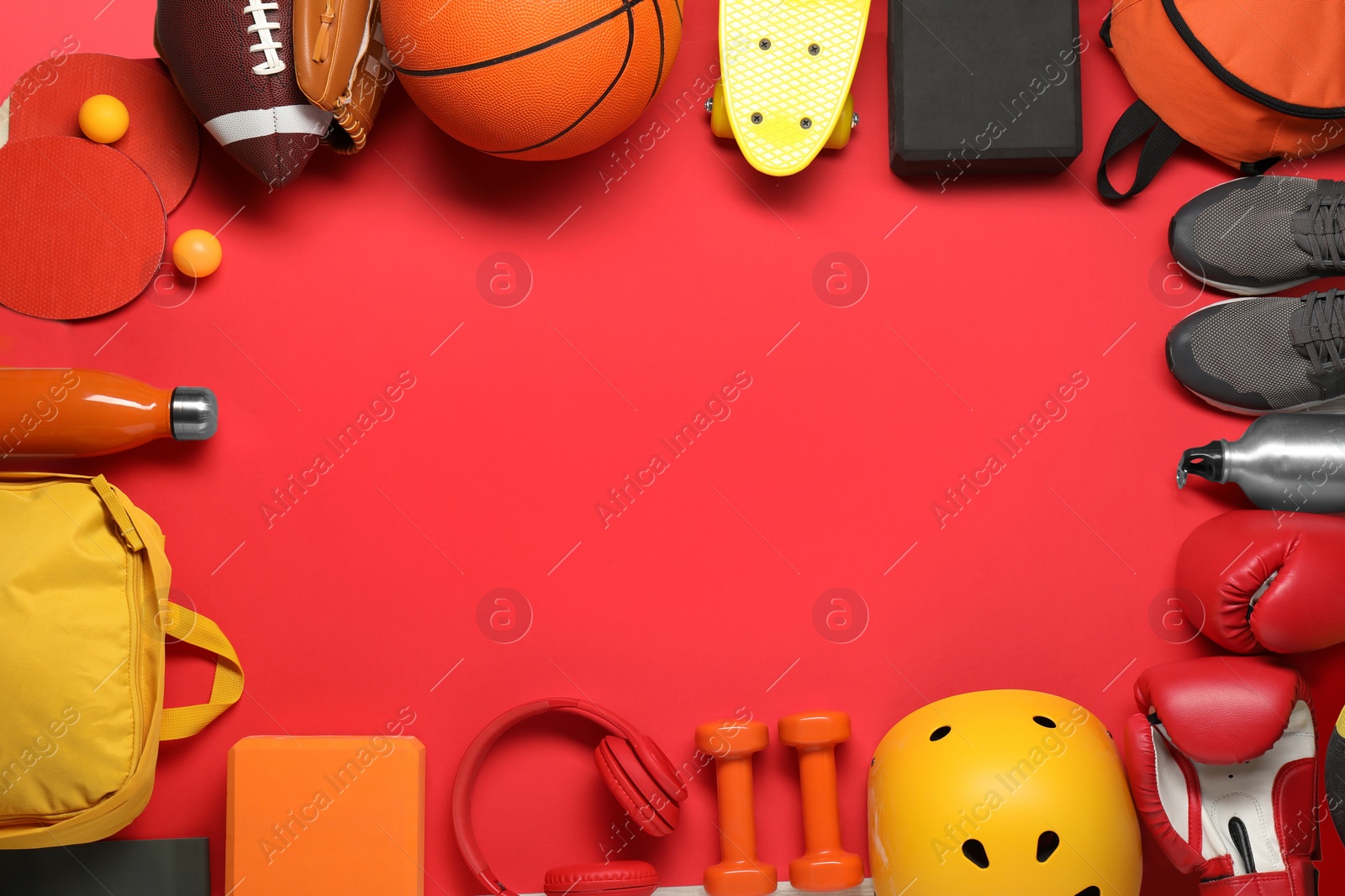 Photo of Frame made of different sports equipment on red background, flat lay. Space for text