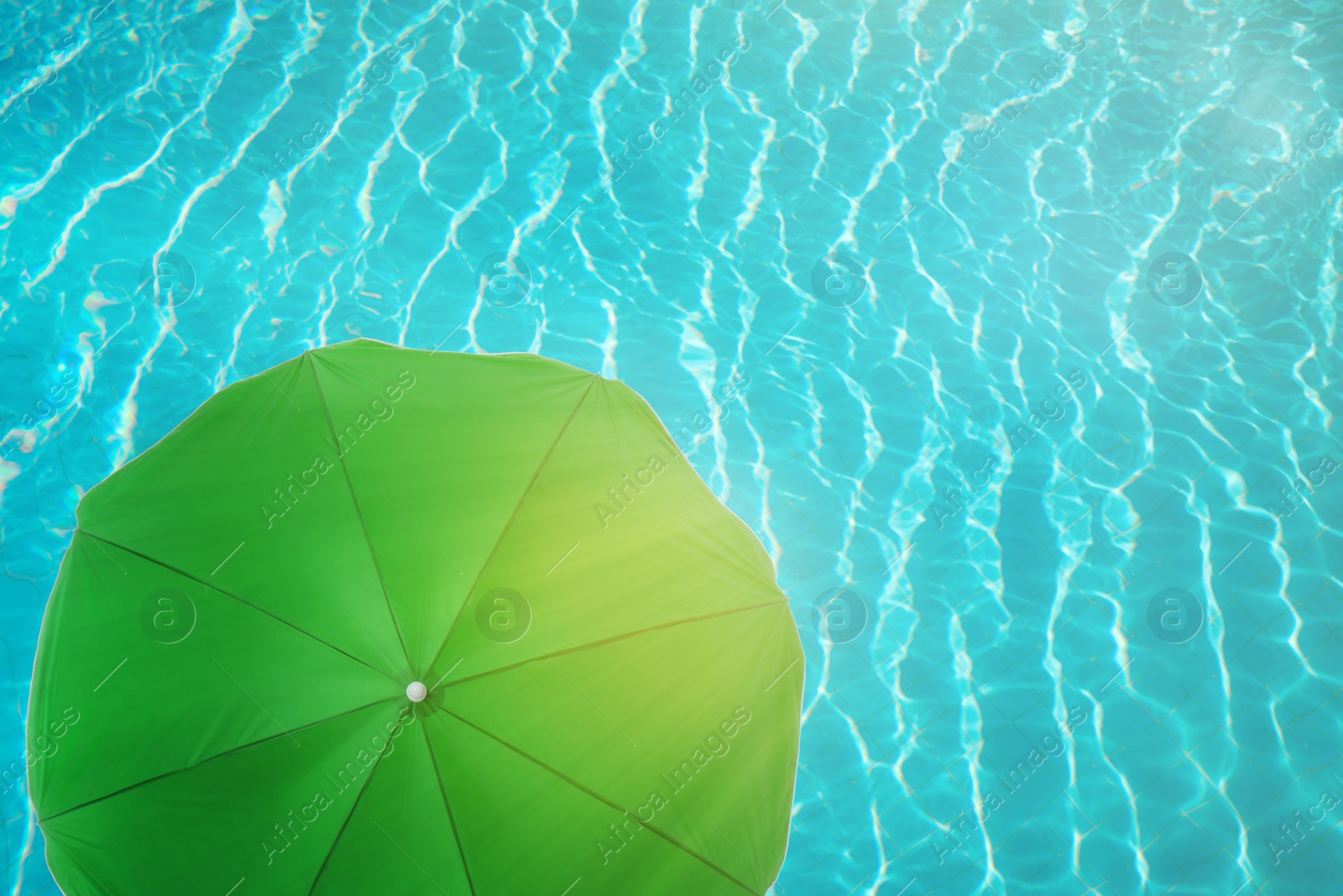 Image of Open beach umbrella and swimming pool. Summer vacation