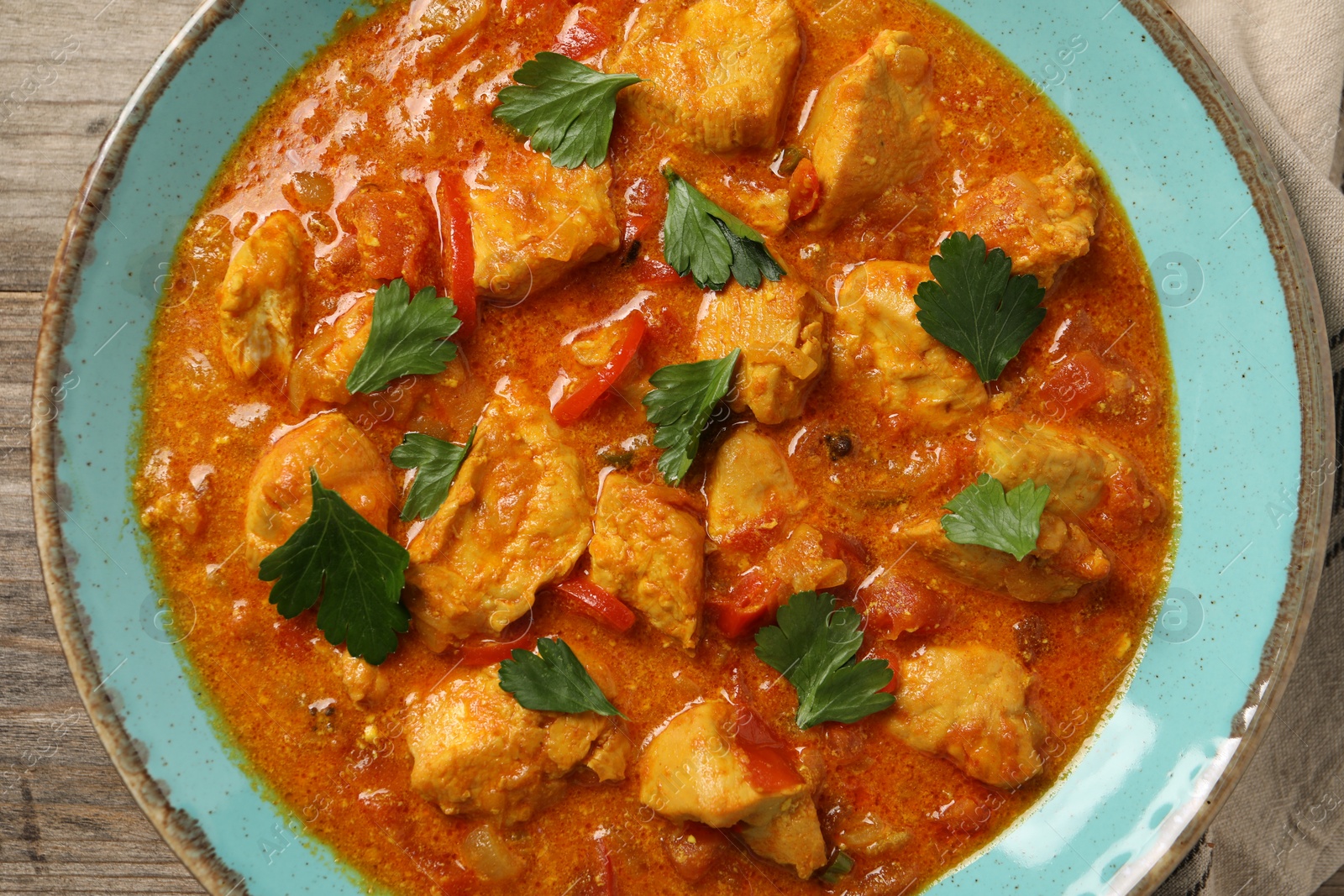 Photo of Delicious chicken curry on wooden table, top view