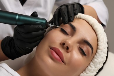 Photo of Young woman undergoing procedurepermanent eyeliner makeup, closeup