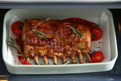 Delicious roasted ribs with tomatoes in oven