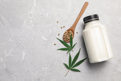 Photo of Flat lay composition with bottle of hemp milk on grey marble table. Space for text