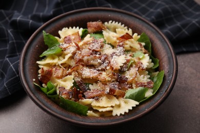 Photo of Tasty pasta with bacon and basil on brown table