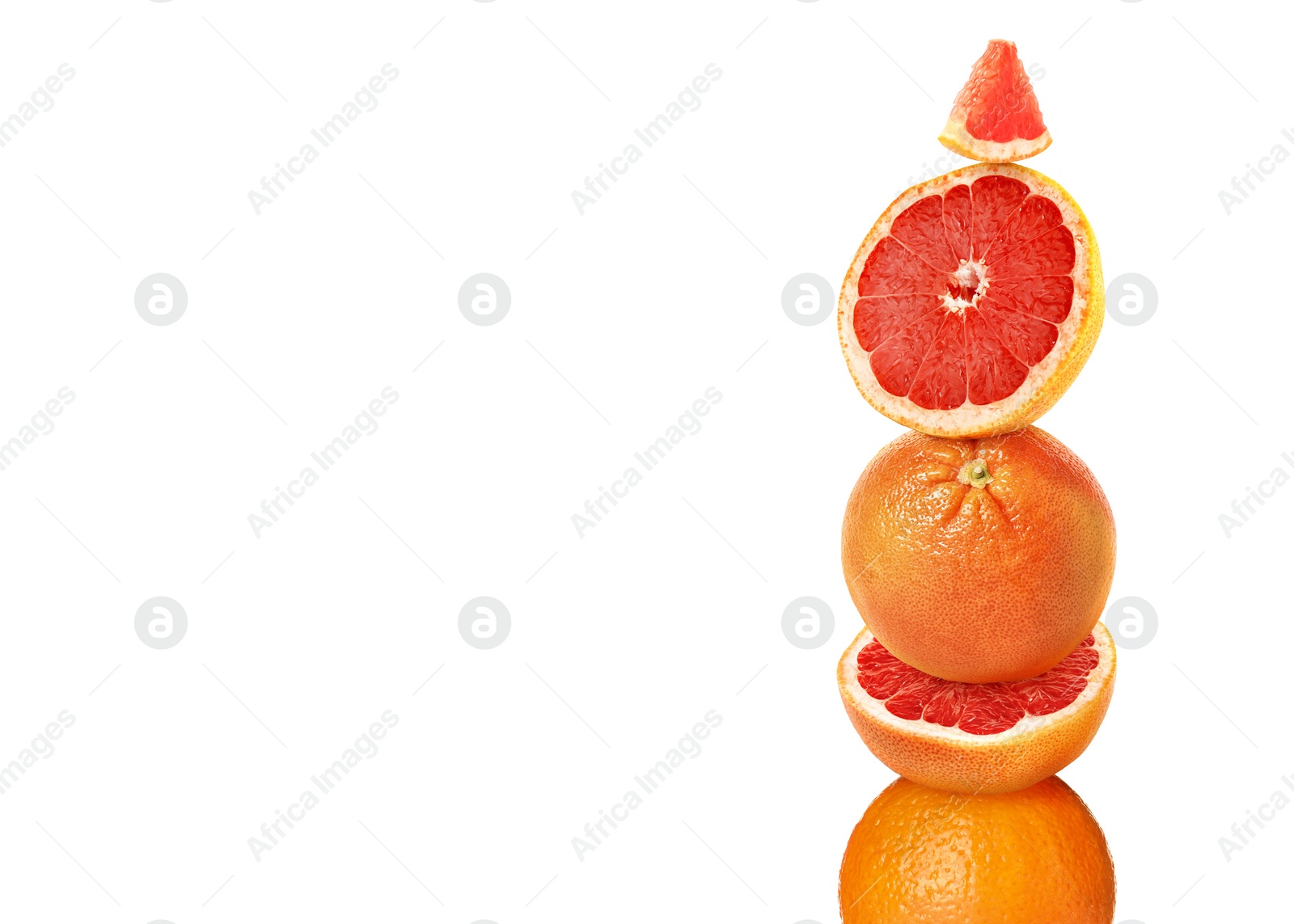 Image of Stacked cut and whole grapefruits on white background