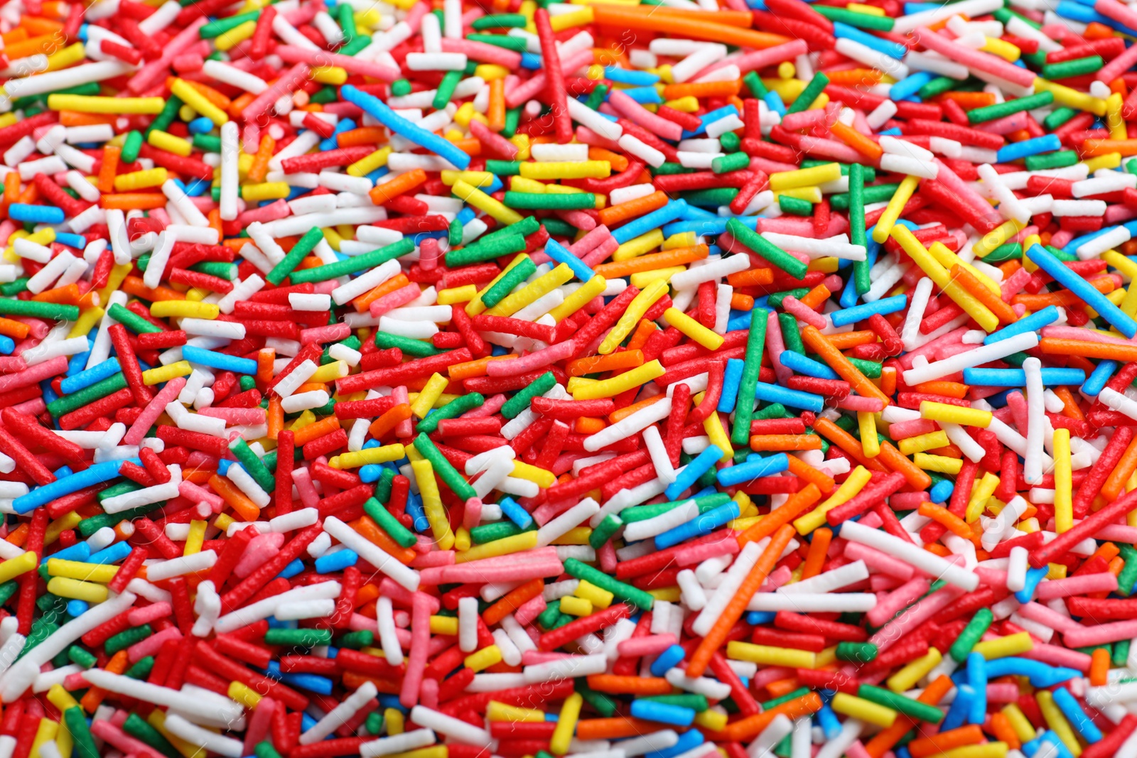 Photo of Bright colorful sprinkles as background, closeup. Confectionery decor