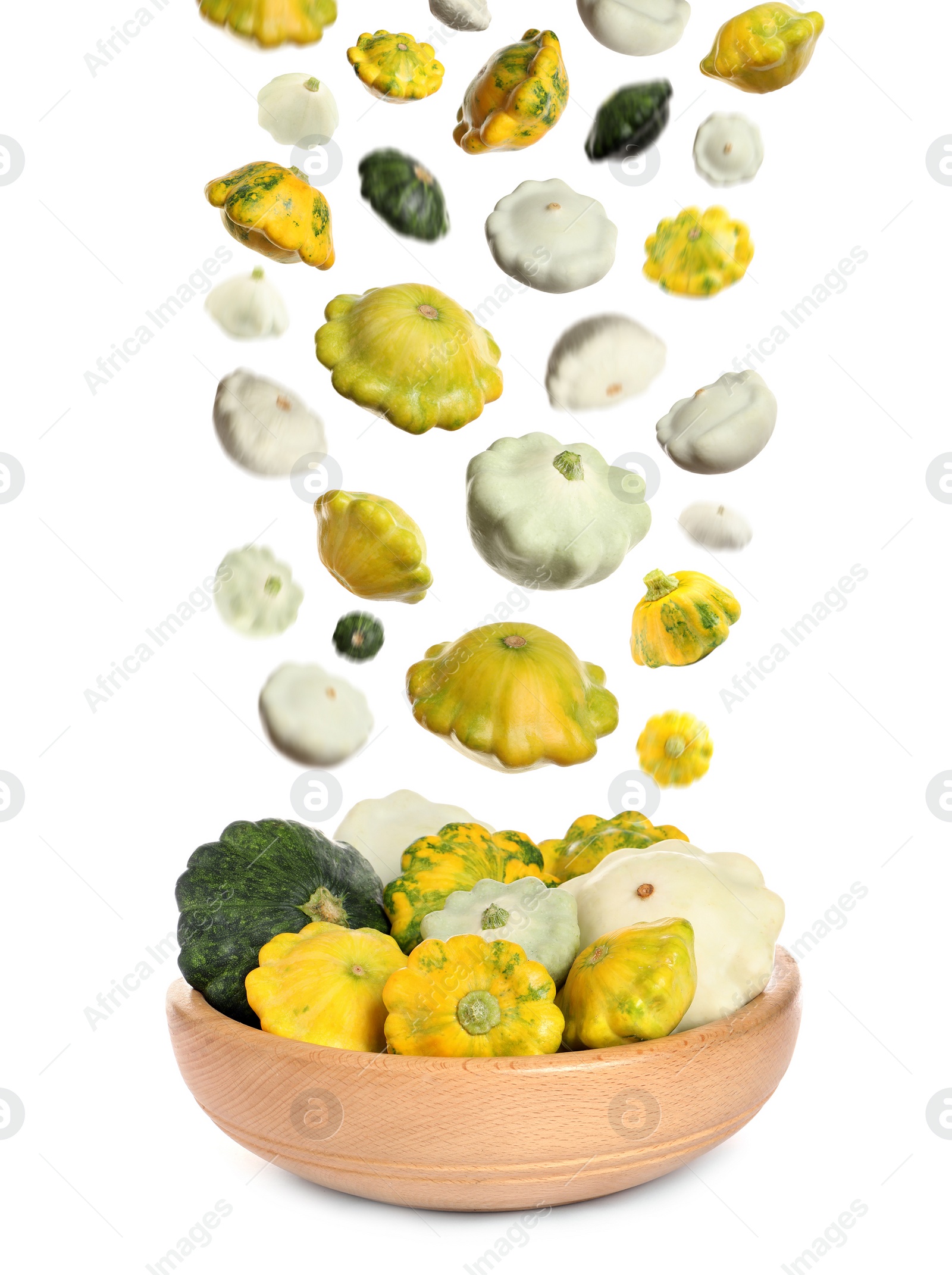 Image of Fresh ripe pattypan squashes falling into bowl on white background 