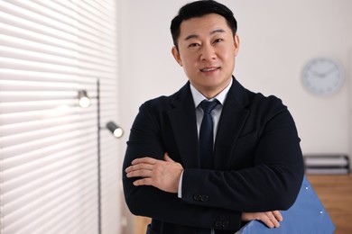 Portrait of happy notary with clipboard in office, space for text