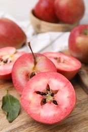 Photo of Tasty apples with red pulp on wooden board, closeup