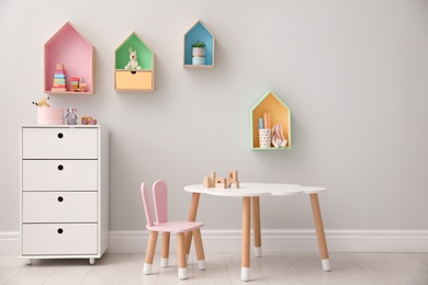 Photo of Children's room interior with house shaped shelves and little table