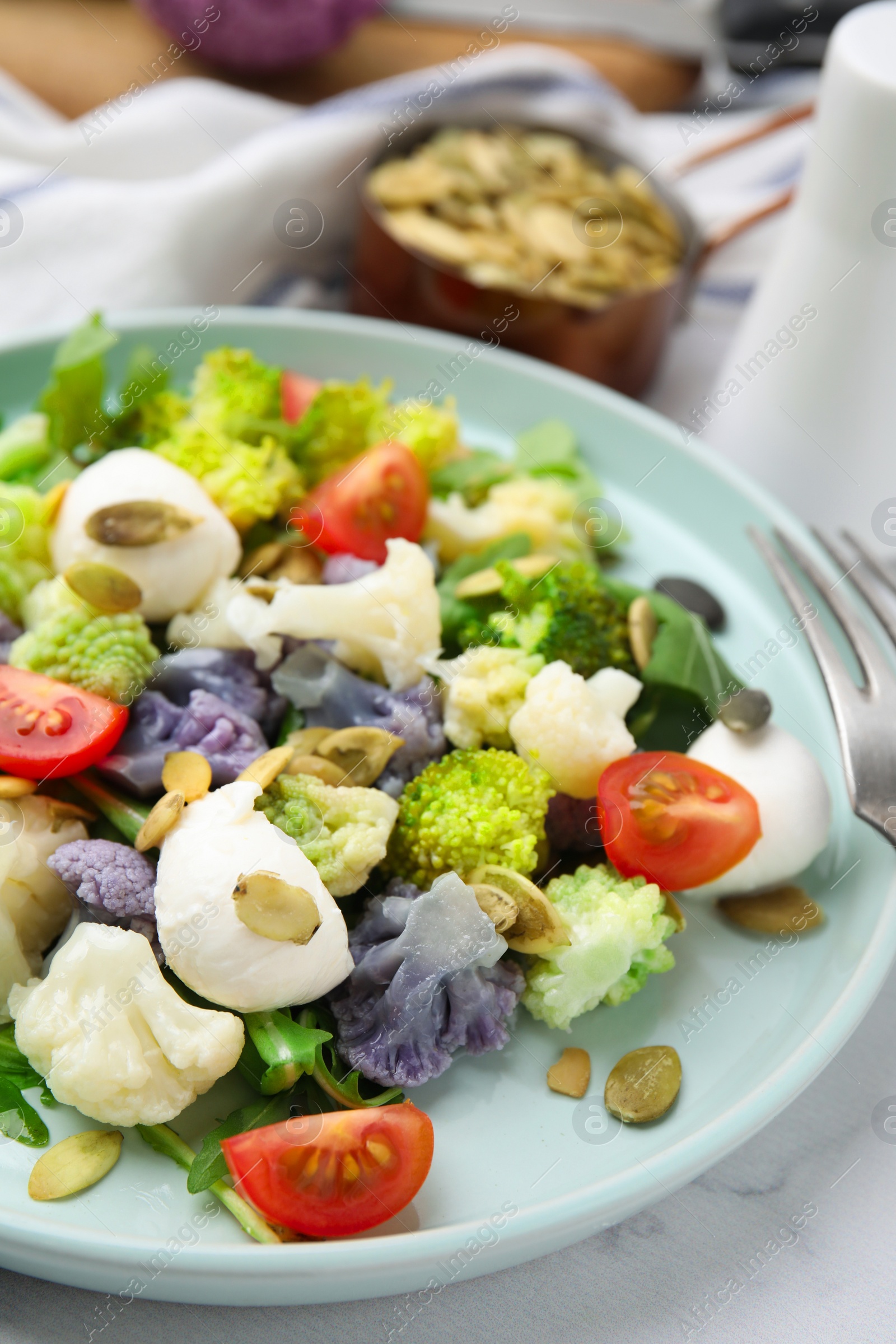 Photo of Delicious salad with cauliflower, tomato and cheese on table, closeup