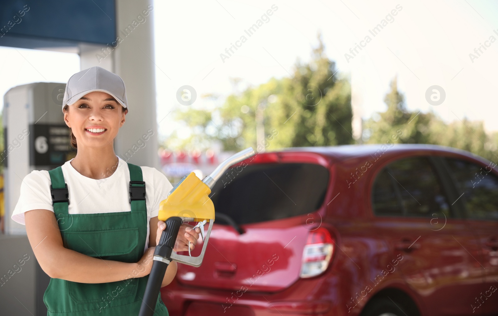 Photo of Worker with fuel pump nozzle at modern gas station