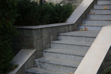 Photo of View of beautiful grey concrete stairs near plants outdoors