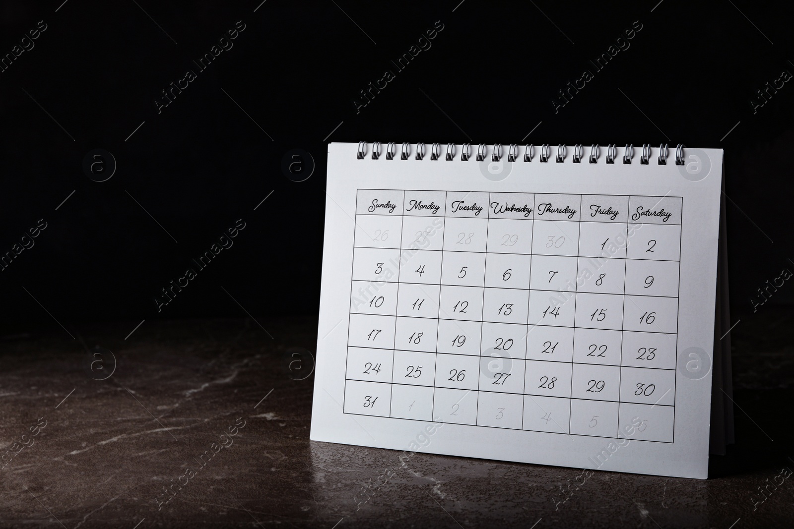 Photo of Paper calendar on stone table, space for text. Planning concept