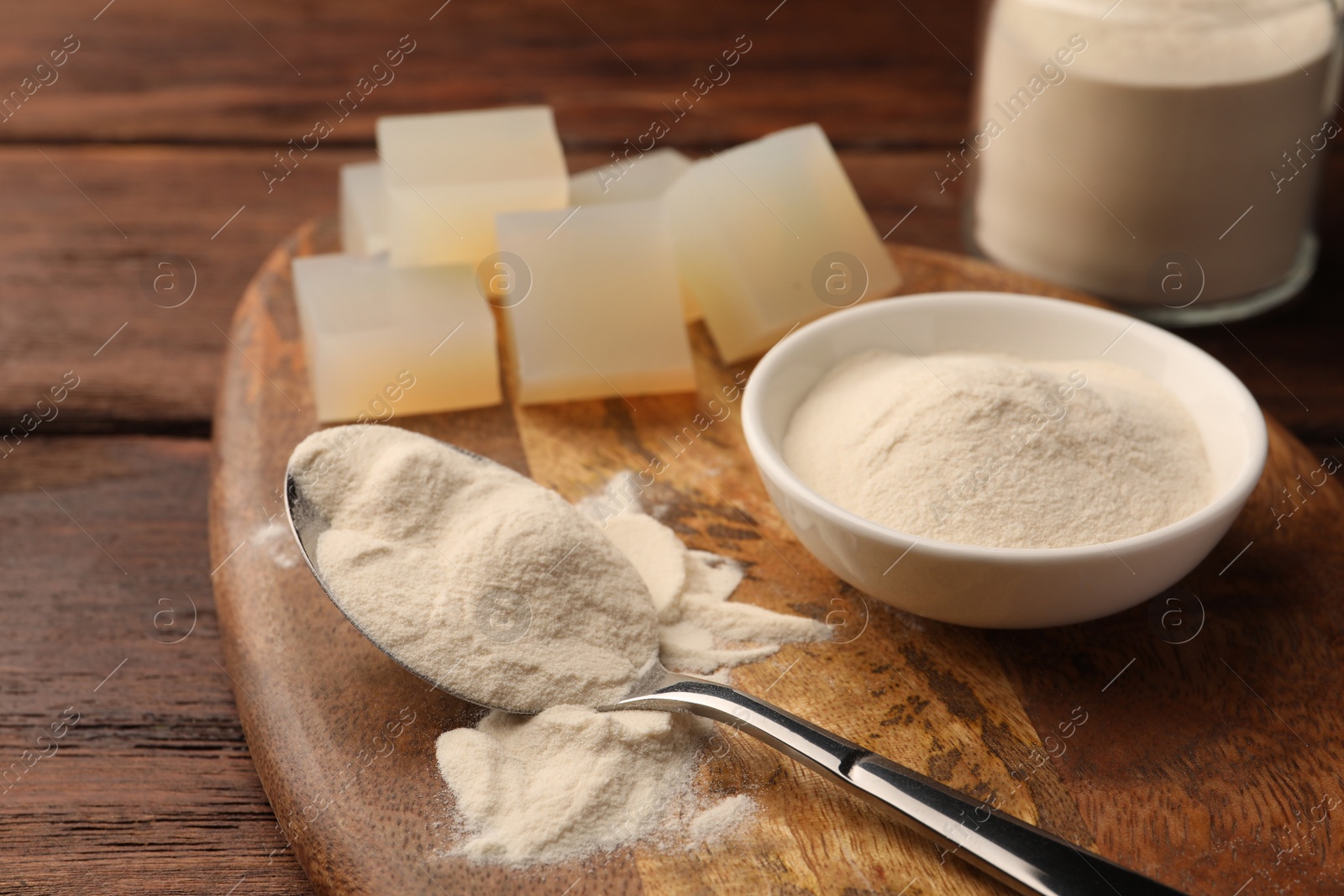 Photo of Agar-agar jelly cubes and powder on wooden table, closeup