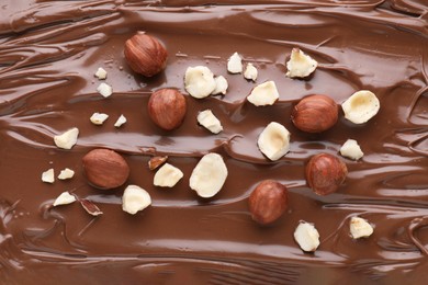 Delicious chocolate paste with nuts as background, top view