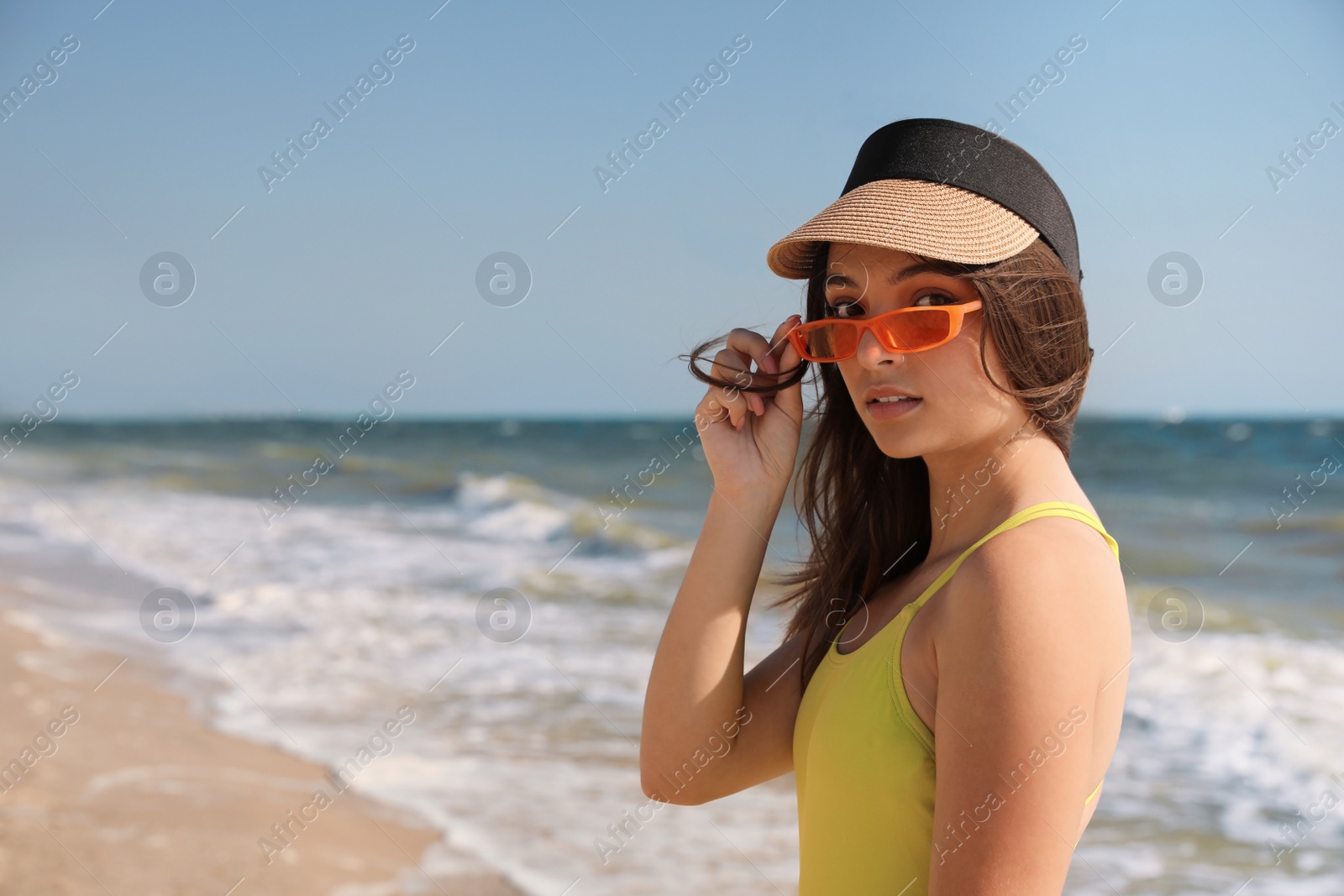 Photo of Beautiful young woman with bright sunglasses on beach