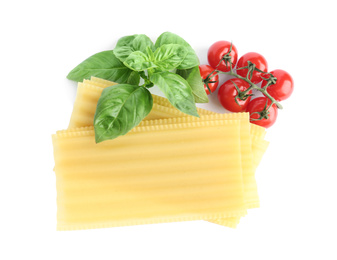 Photo of Uncooked lasagna sheets, cherry tomatoes and basil isolated on white, top view