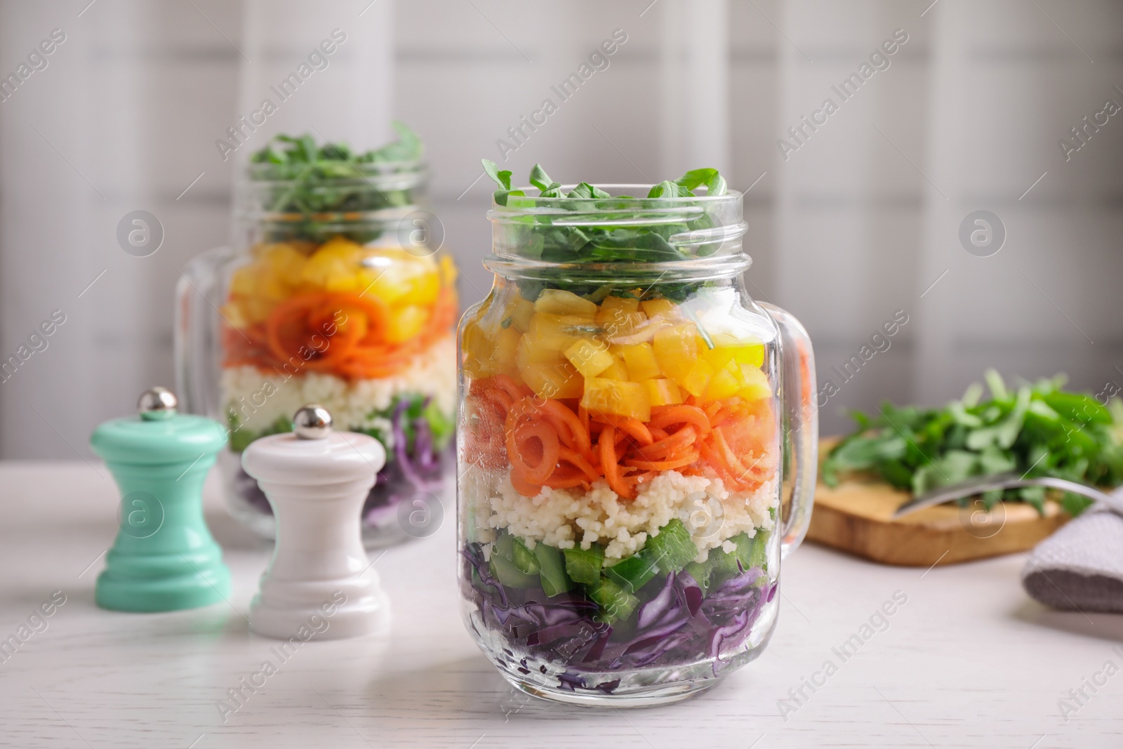 Photo of Healthy salad in glass jar on white wooden table