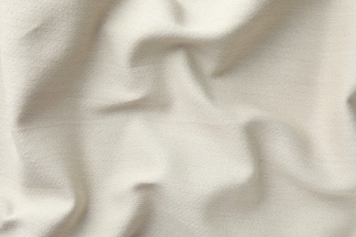 Photo of Texture of beige crumpled fabric as background, top view