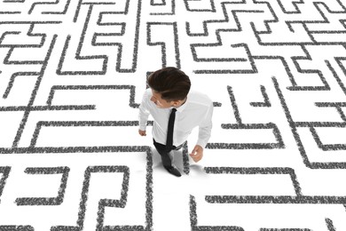 Image of Thoughtful businessman and illustration of maze on white background