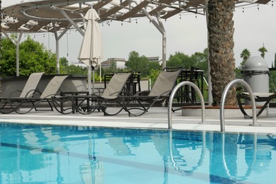 Ladder with handrails in outdoor swimming pool