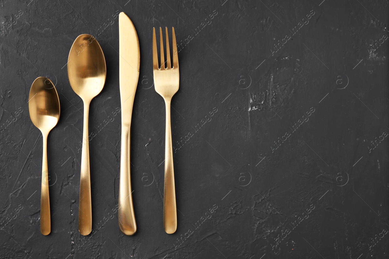 Photo of Beautiful cutlery set on black table, flat lay. Space for text