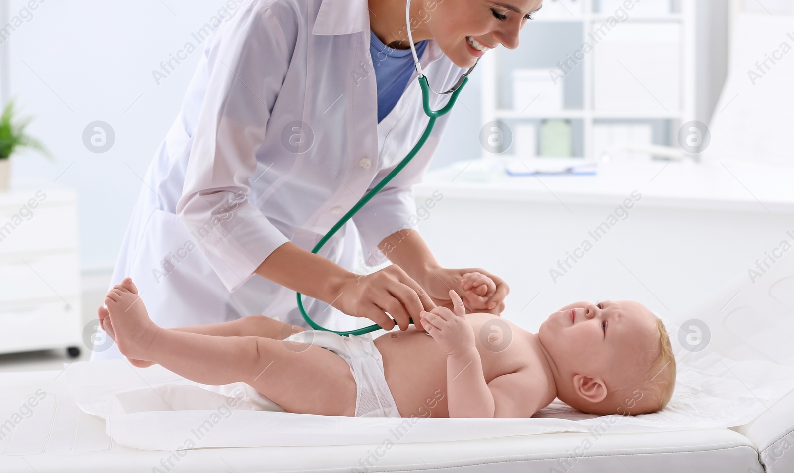 Photo of Children's doctor examining baby with stethoscope in hospital